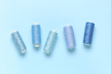 Fototapeta premium Spools of thread on blue background