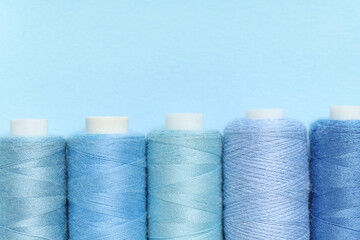 Spools of thread on blue background, closeup
