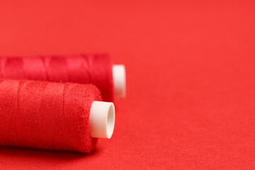 Spools of thread on red background, closeup