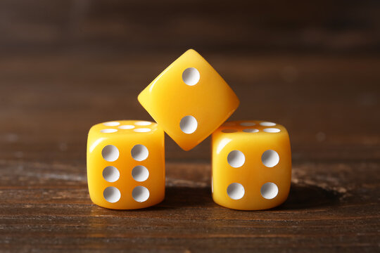 Yellow game dices on wooden background
