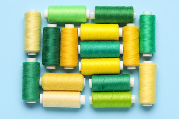Different sewing thread spool on blue background, closeup