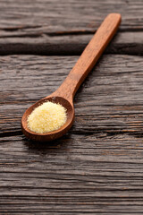 Coarse wheat semolina flour in a wooden spoon - Triticum