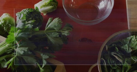 Showing bunch of parsley on red cutting board beside glass mixing bowl in kitchen, copy space