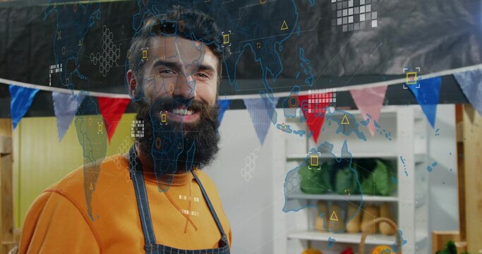 Smiling bearded vendor wearing dark apron showing plants and pennants at stall with data overlay