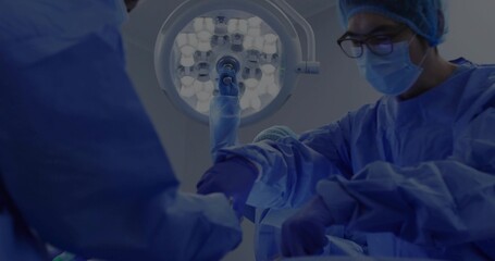 Performing surgery Asian surgeon handling forceps in surgical suite under LED lamp, copy space