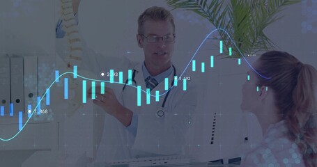 Doctor wearing stethoscope explaining spine model to patient in office, with digital chart overlay