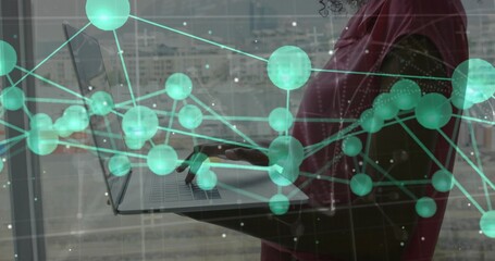 Woman wearing red blazer typing on laptop with network overlay in office by window, copy space