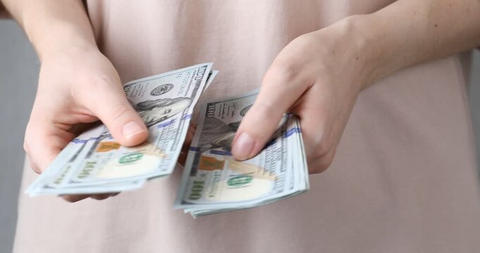 Alimony. Woman counting dollar banknotes, closeup view