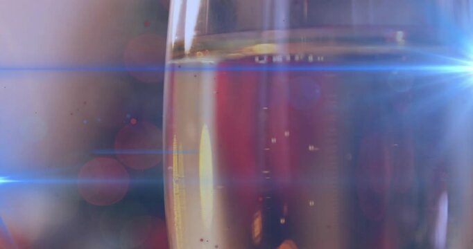 Opening closeup showing flute glass rising bubbles and sweeping lensflare emphasizing effervescence