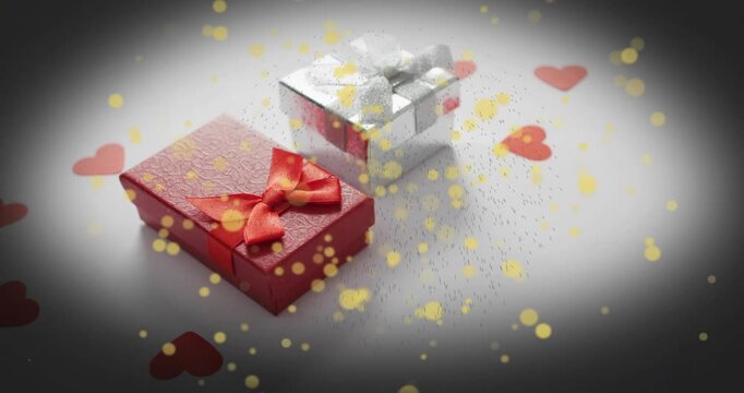 Golden confetti drifting into frame and swirling around two gift boxes highlighting romantic theme