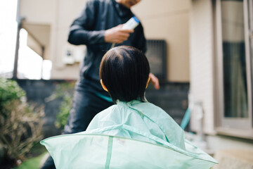 外で散髪される子供