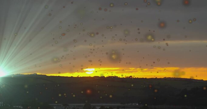 Intensifying sunrise glow sparking searchlight burst moving beams scanning hills and glass surfaces