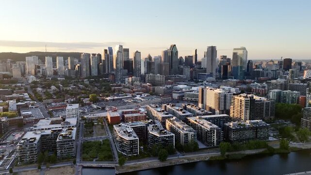 Aerial view of modern waterfront district with high-rise buildings and riverside paths, Montreal twilight skyline. g.