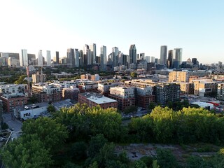 Obraz premium Aerial view of modern waterfront district with high-rise buildings and riverside paths, Montreal twilight skyline. g.