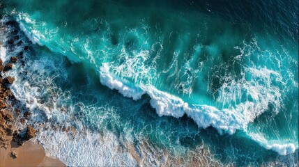 Fototapeta premium Turquoise waves crash on the shore, captured in a stunning aerial view. Use it to convey peace, adventure, or the beauty of the sea.