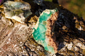 A bright green chrysoprase lies next to a simple opal