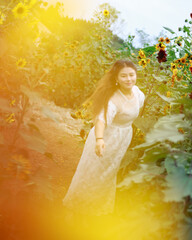 An Asian girl is laughing among the sunflowers