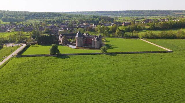 castle lavaux sainte anne or ch&acirc;teau de green cover surrounding water body to from left around right aerial drone panning shot 
