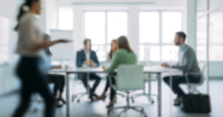 Realistic DSLR photograph of a business meeting with professionals seated around a modern table in a bright office, sunlight reflecting on glass surfaces and laptops.