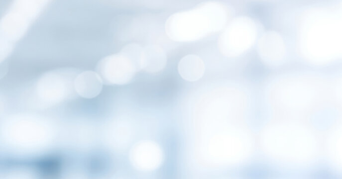 Abstract DSLR blurred business background in shades of white and light blue with subtle bokeh, creating a calm bright and professional atmosphere.