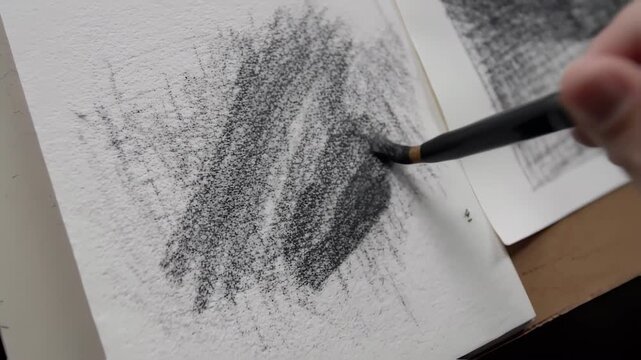 Graphite drawing in progress on paper.  A textured application of graphite is being applied with a brush