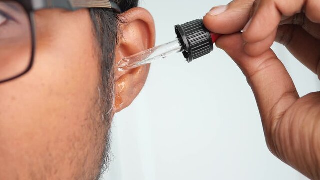 Man applying ear drops at home for relief