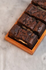Chocolate banana loaf, sliced, on wood tray, marble backdrop