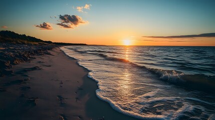 A picturesque sunset over a calm ocean with foamy waves lapping onto a sandy beach.