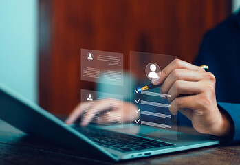 Businessman using laptop to evaluate candidate profiles on digital interface, representing recruitment process, human resource management, data analysis, and HR technology for modern business.