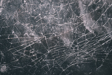 The glass surface is cracked with a complex random crack pattern. The texture of the broken glass is clearly visible with detailed fine crack lines spreading across the surface.