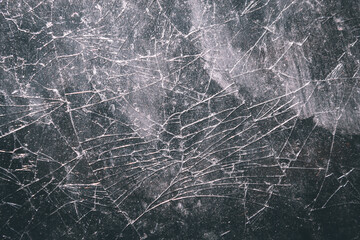 The glass surface is cracked with a complex random crack pattern. The texture of the broken glass...