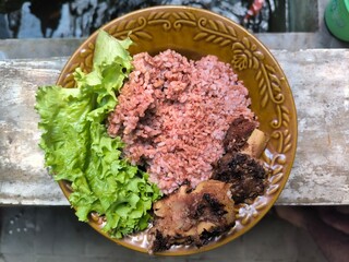 Grilled ribs served with brown rice and green lettuce.
