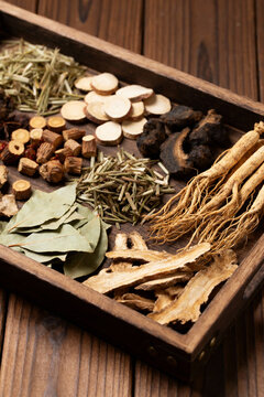 traditional Chinese herbal medicine displayed on wooden tray with dried plants, roots and leaves, natural healing, holistic health, wellness concept, apothecary style.Generated by AI