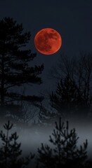 Fototapeta premium A vibrant red moon dominates a dark, misty forest landscape at night.