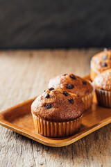 Delicious Chocolate Chip Muffins on Wooden Tray with Rustic Background