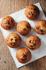 Freshly Baked Muffins with Chocolate Chips on Rustic Wooden Table