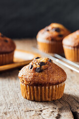 Freshly Baked Muffin with Chocolate Chips on Rustic Wooden Table