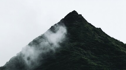 A rugged volcanic peak towers with dense green vegetation,