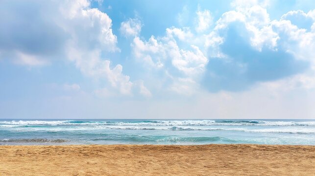 A beautiful beach scene with sandy shores leading into calm ocean waters and gentle waves under a bright blue sky filled