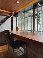 Comfortable space furnished with a long wooden table and chairs facing the glass window is perfect for a workspace, reading room or study room. For background ideas