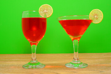 Cocktail juice glasses together with green background closeup view 