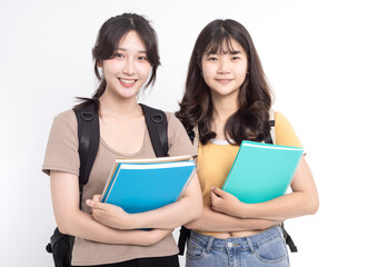 Two happy asian female students carrying notebooks and backpack