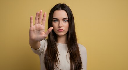 Serious young woman holding hand up to signal stop.