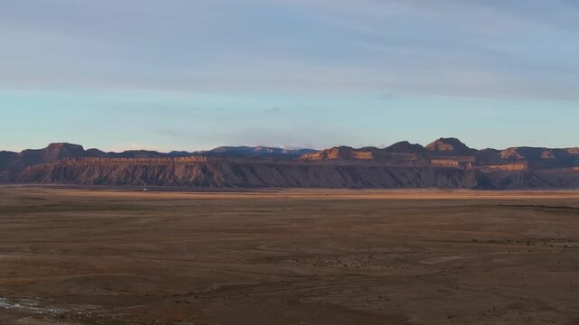 Moab desert landscape at sunset with wide open plains and distant mountains