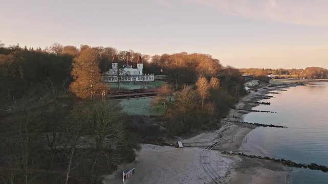 Drone footage of Marselisborg Forest, the beach and Varna Mansion in late autumn near Aarhus, Denmark. Bare trees and soft coastal light capture a quiet Nordic atmosphere.
