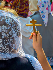 Femme russe de dos portant un foulard pour l'église sur la tête et tenant une petite croix orthodoxe dans la main pendant une procession. Concepts de religion chrétienne orthodoxe et de foi religieuse