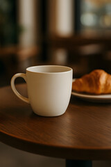 Fototapeta premium White coffee cup with croissant on wooden table — warm cozy morning scene