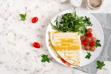 Healthy breakfast. Lavash with cheese, tomatoes, and herbs. Fresh salad. Top view