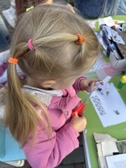 A girl cuts paper with scissors at a collage workshop