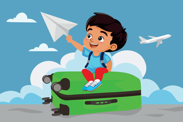 Happy boy sitting on suitcase with paper plane